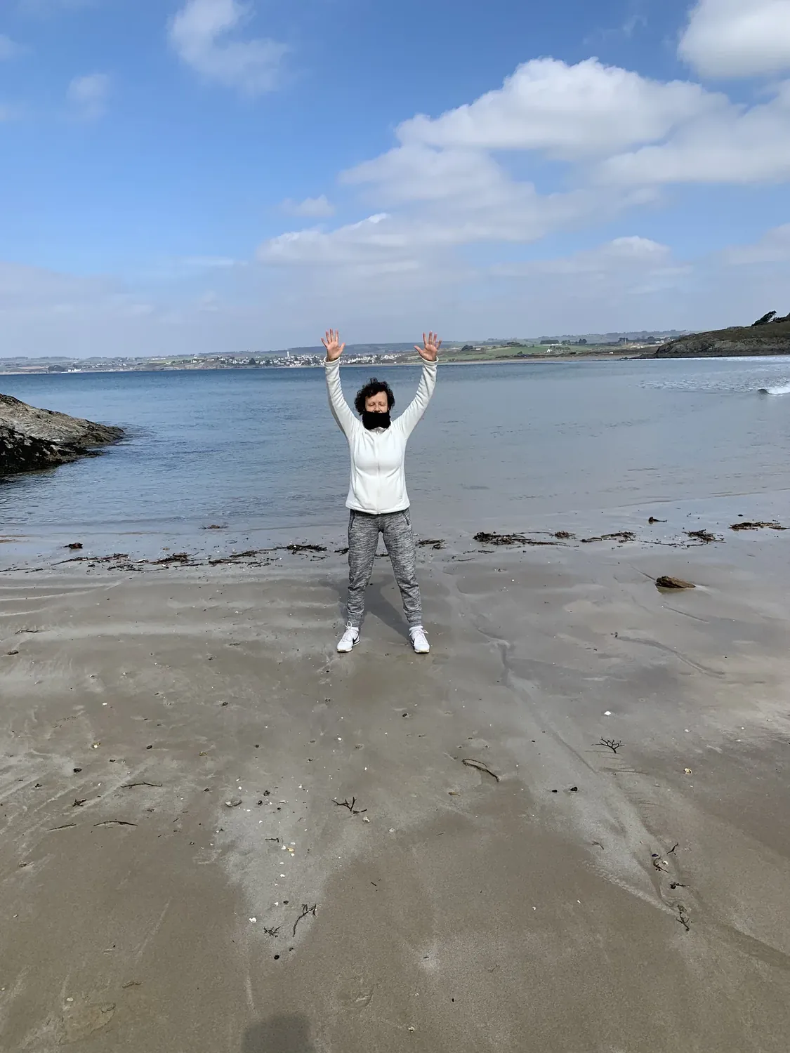 Sylvie Gonidec, les bras levés sur une plage bretonne